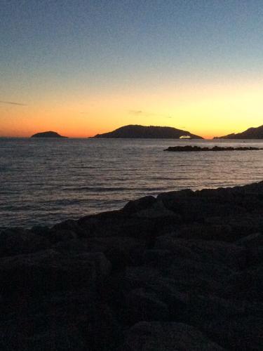 a sunset over the ocean with mountains in the distance at Cinqueterre Alla Chetichella in Lerici