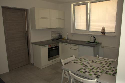 a kitchen with a table and a stove top oven at Dom przy plaży in Dźwirzyno