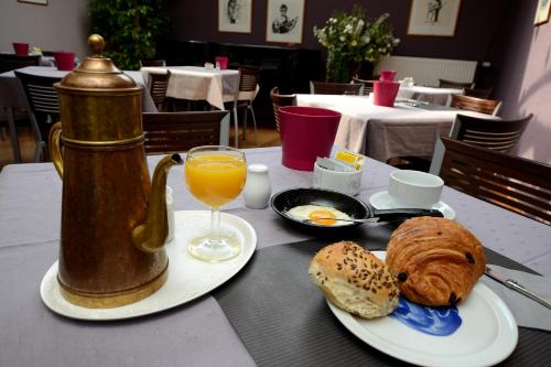 una mesa con desayuno de pan y zumo de naranja en Focus Boutique, en Cortrique