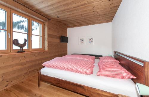 a bedroom with a bed with red and white pillows at Alpin Chalet Schröcken in Schröcken