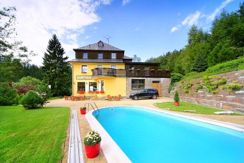 ein Haus mit einem Swimmingpool vor einem Haus in der Unterkunft Lucni Dum in Janské Lázně