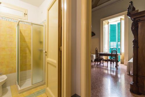 y baño con ducha de cristal y mesa. en Palazzo Leuzzi B&B, en Galatone