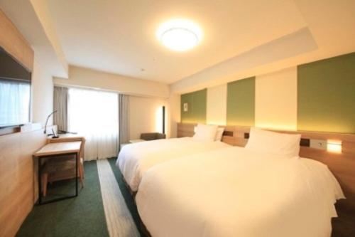 a hotel room with two beds and a window at Richmond Hotel Tenjin Nishi-Dori in Fukuoka
