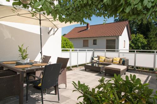 a patio with a table and chairs and a couch at DeuxPonts Ferienwohnung in Zweibrücken