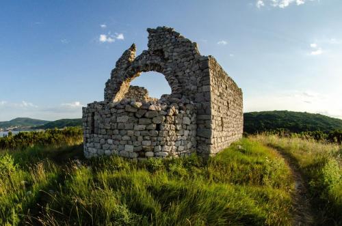 an old stone wall in a grassy field at Studio apartman Braco in Risika