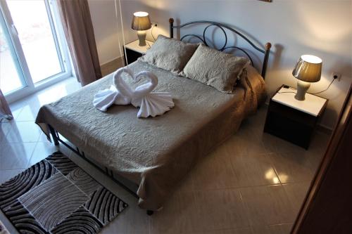 ein Schlafzimmer mit einem Bett mit einer weißen Schleife darauf in der Unterkunft Evans Villa in Arkasa