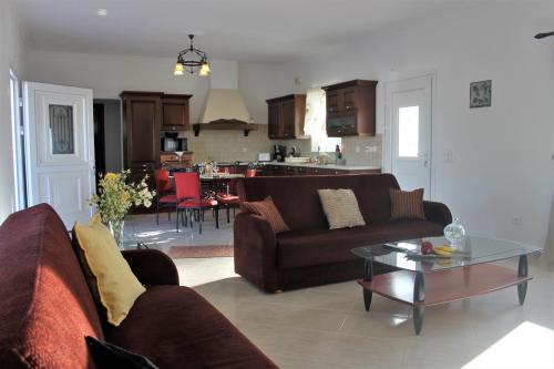 ein Wohnzimmer mit zwei braunen Sofas und einem Tisch in der Unterkunft Evans Villa in Arkasa