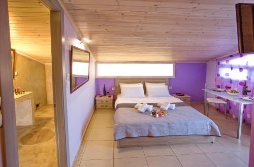 a bedroom with a large bed with purple walls at Lazy Lizard in Néa Karváli