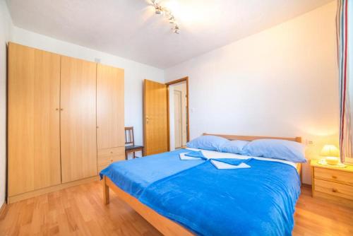 a bedroom with a blue bed and a wooden cabinet at Marijan in Pula