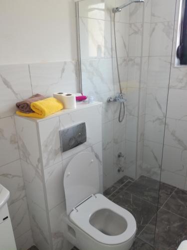 a white bathroom with a shower and a toilet at Olea in Tivat