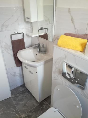 a white bathroom with a sink and a toilet at Olea in Tivat