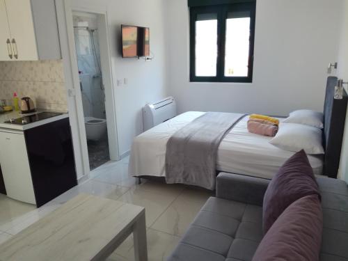 a bedroom with a bed and a couch and a bathroom at Olea in Tivat