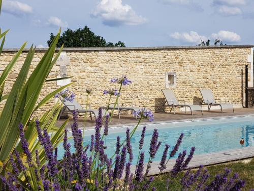 a villa with a swimming pool and purple flowers at Les Hauts De Chalonne in Le Gond-Pontouvre