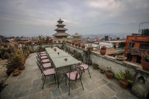 a table and chairs on a balcony with a view at Golden Gate Guest House in Bhaktapur
