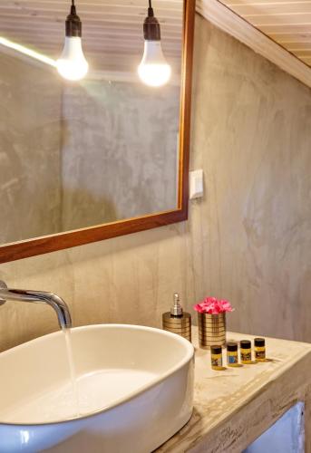 a bathroom with a white sink and a mirror at Lazy Lizard in Néa Karváli