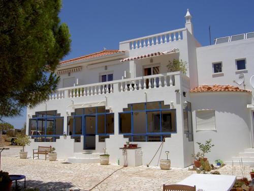 a large white building with blue windows on it at Quartos Com Boas Vistas in Ribeira da Gafa