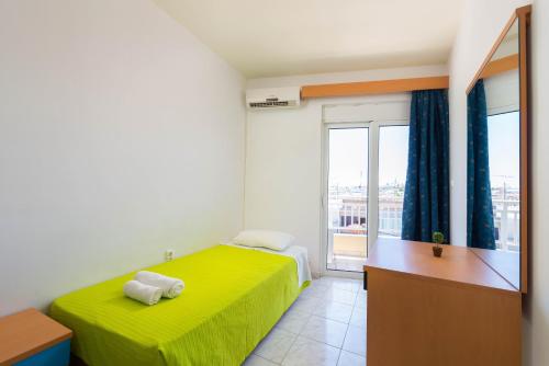 a bedroom with a green bed and a window at Yiannis Apartments in Rhodes Town