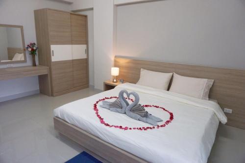 a bedroom with a bed with two swans forming a heart at JVAPLACE in Nonthaburi