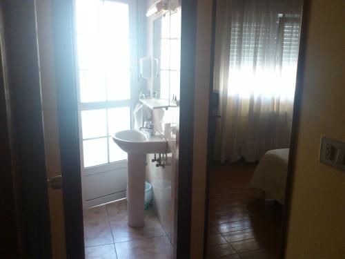 a bathroom with a sink and a window at Hostal Fisterra in Lugo