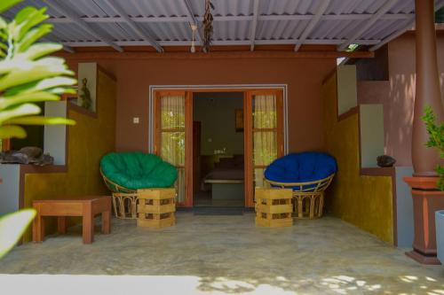 a model of a house with two chairs and a table at Richards Cabanas in Tissamaharama