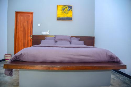 a bedroom with a bed with a wooden headboard at Richards Cabanas in Tissamaharama