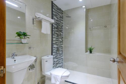 een badkamer met een toilet, een wastafel en een douche bij The Akoya Saigon Hotel in Ho Chi Minh-stad