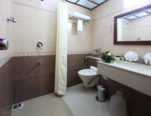 a bathroom with a toilet and a sink and a shower at Palakunnel residency in Ettumānūr