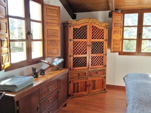 a large wooden cabinet in a room with windows at Cortijo Berruguilla in Lojilla