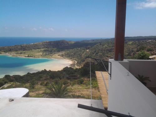a balcony of a house with a view of a beach at Dammuso La Stella del Lago in Pantelleria