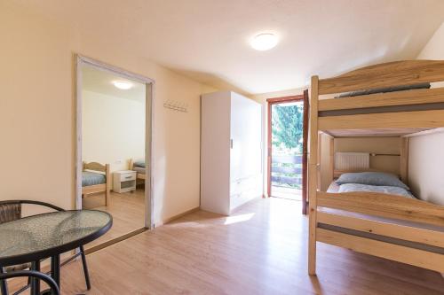 a bedroom with a bunk bed and a table at Dolar Rooms in Bled