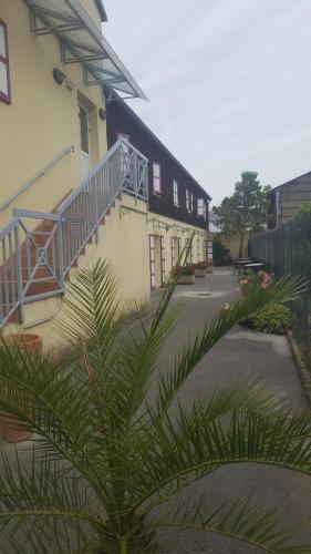 a building with stairs and a plant in front of it at Le Cheval Rouge in Louhans