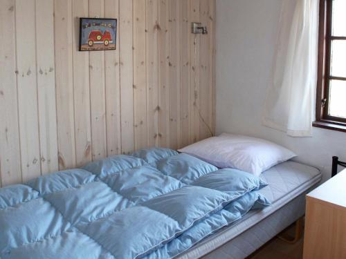 ホにあるThree-Bedroom Holiday home in Blåvand 42の部屋の隅に青いシーツが備わるベッド1台