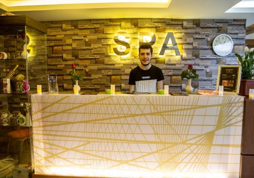 a man standing behind a counter in a restaurant at Bursa Palas Hotel in Bursa