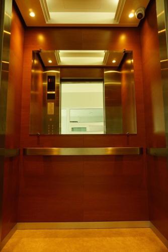 a bathroom with a mirror and a wooden door at JVAPLACE in Nonthaburi