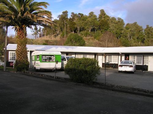 a building with two cars parked in a parking lot at Coachman Motel in Taihape