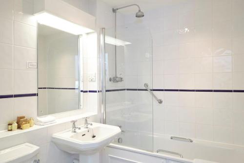 a white bathroom with a sink and a shower at The Royal Hotel in Ventnor