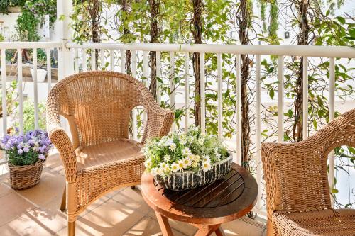 a porch with two chairs and a table with a basket of flowers at La Goleta in Llança