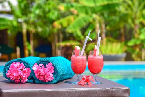 two glasses of pink drinks sitting on a table at Richards Cabanas in Tissamaharama
