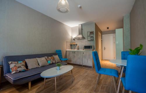 sala de estar con sofá, mesas y cocina en New Gudauri, Red Co. Loft 2., en Gudauri
