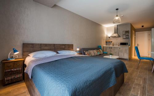 Un dormitorio con una cama grande con una manta azul. en New Gudauri, Red Co. Loft 2., en Gudauri