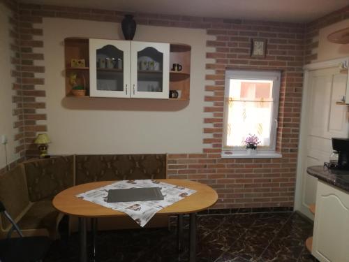 a kitchen with a table and a brick wall at Pensiunea Colt Alb in Băile Homorod