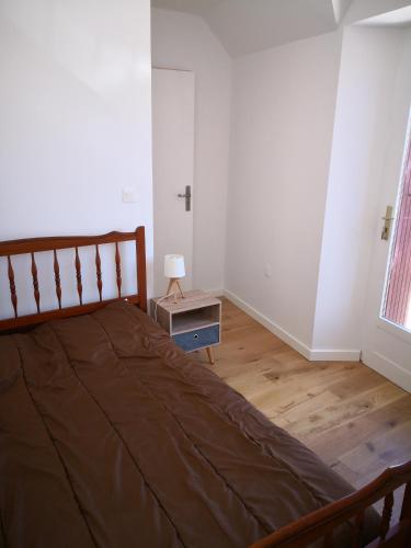 une chambre avec un lit et une table avec une lampe dans l'établissement Appartement Rue Haute des Bains, au Croisic