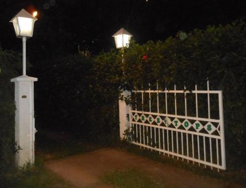 a white fence with a street light next to a bush at Treetops Boutique Hotel & Bungalows in Port Vila