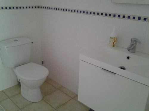 une salle de bain blanche avec des toilettes et un lavabo dans l'établissement Érable Pourpre, à Saint-Georges-Haute-Ville