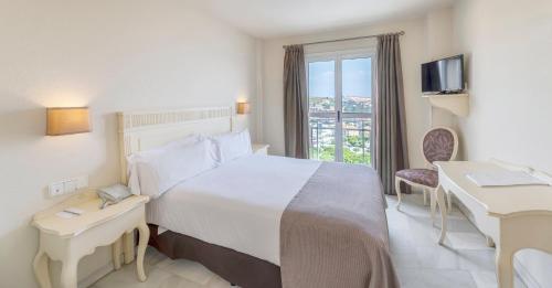 a hotel room with a large bed and a window at Hotel Suances in Suances