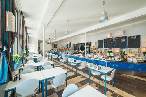 a restaurant with white tables and chairs and a counter at Sopocki Zdrój in Sopot