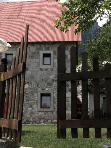 a barn with a red roof and a wooden fence at Molla Guest House in Theth