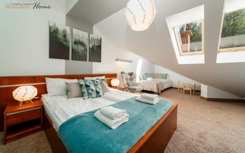 sypialnia z dużym łóżkiem z ręcznikami w obiekcie Wonder Home - Apartament Zaciszny z kominkiem i balkonem z widokiem na Śnieżkę w mieście Karpacz