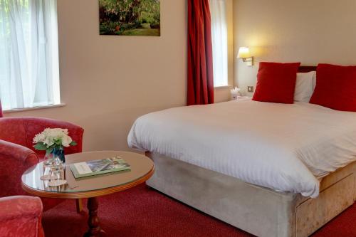 a bedroom with a bed and a table and a chair at Best Western Plus Bentley Hotel in Lincoln