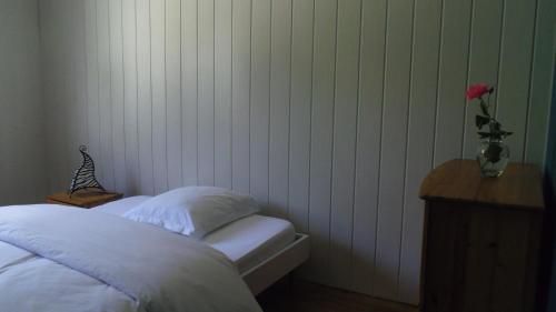 - une chambre avec un lit et un vase avec une rose dans l'établissement Chambre meublée sympa proche centre ville Lorient, à Lorient